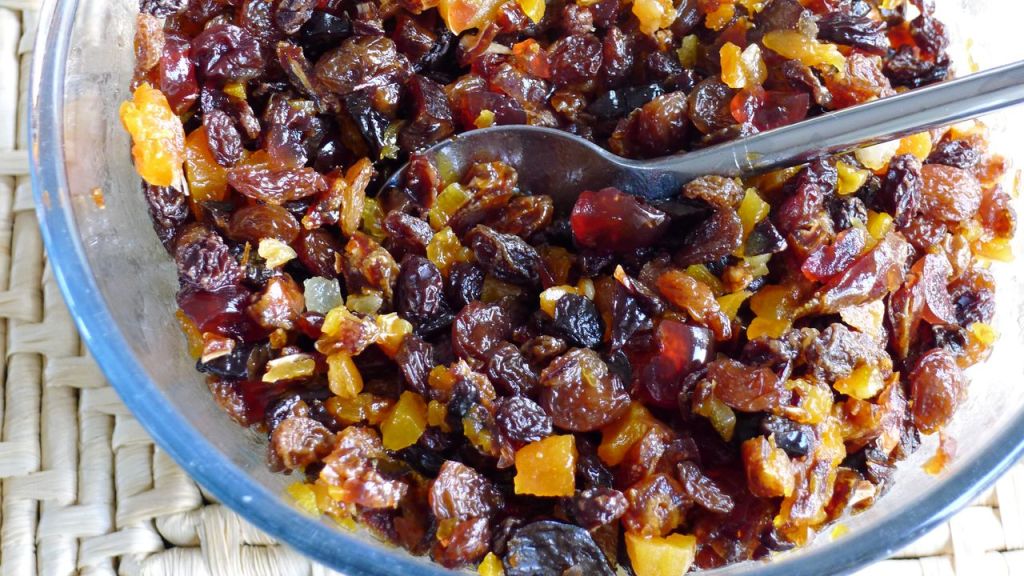 A close up of a glass bowl full of dried fruits soaking. 