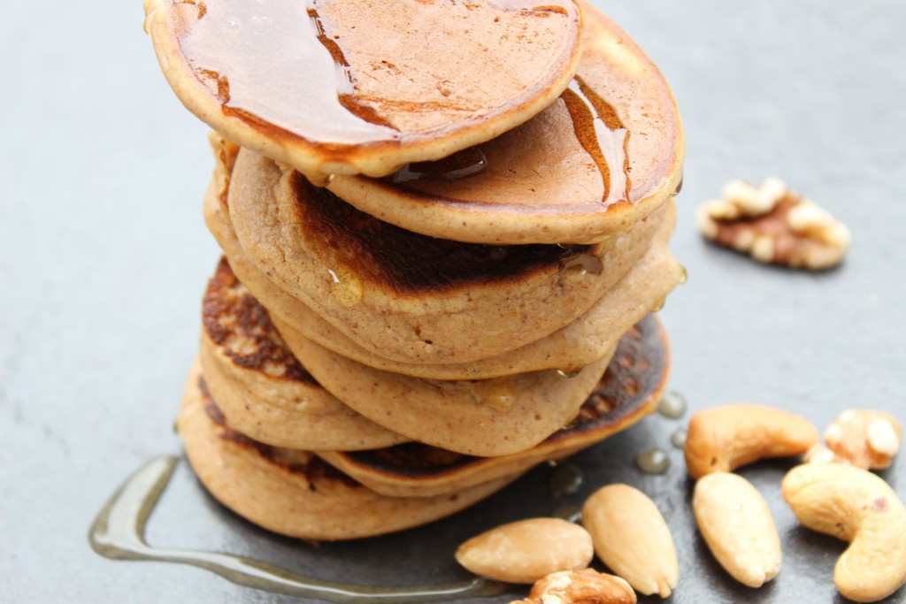 Banana pancakes drizzled with honey and scattered with nuts