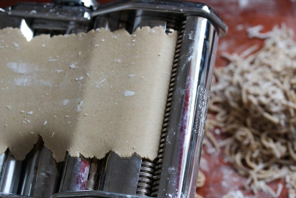 Gluten free pasta dough being passed through a pasta machine