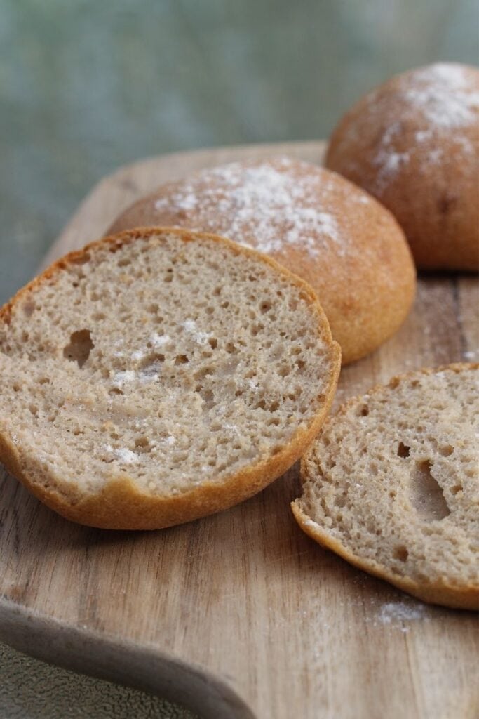 A cut open gluten free sandwich roll showing the soft texture inside.