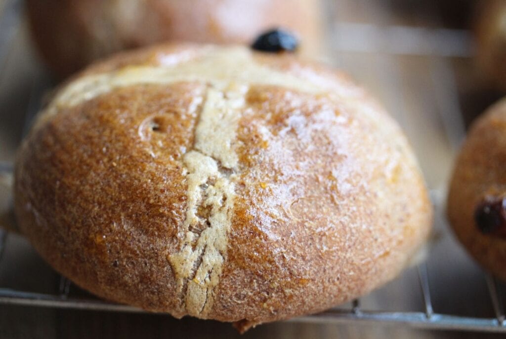 Gluten free hot cross bun close up on wire rack