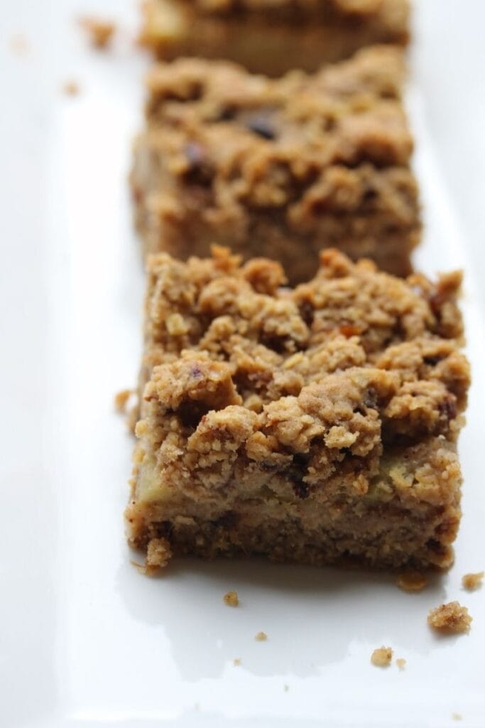 Three apple crumble flapjacks on a white plate