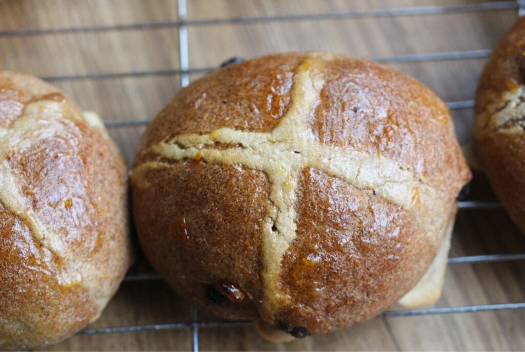 Top view of hot cross buns cooling on a wire rack